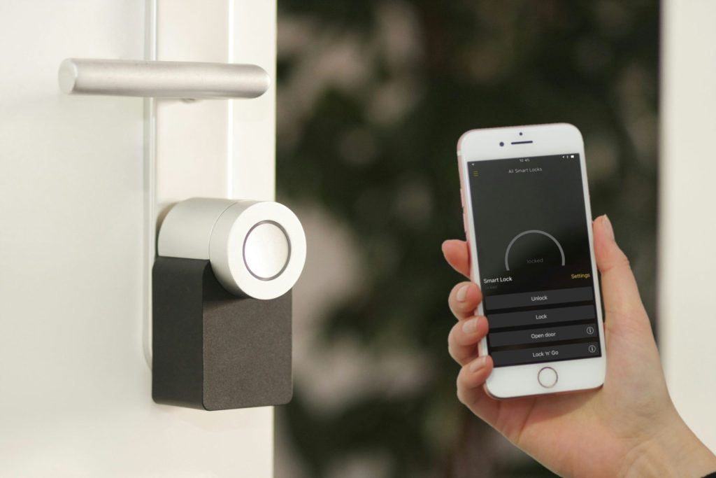 Smartphone Apple iPhone dorado sostenido en la puerta